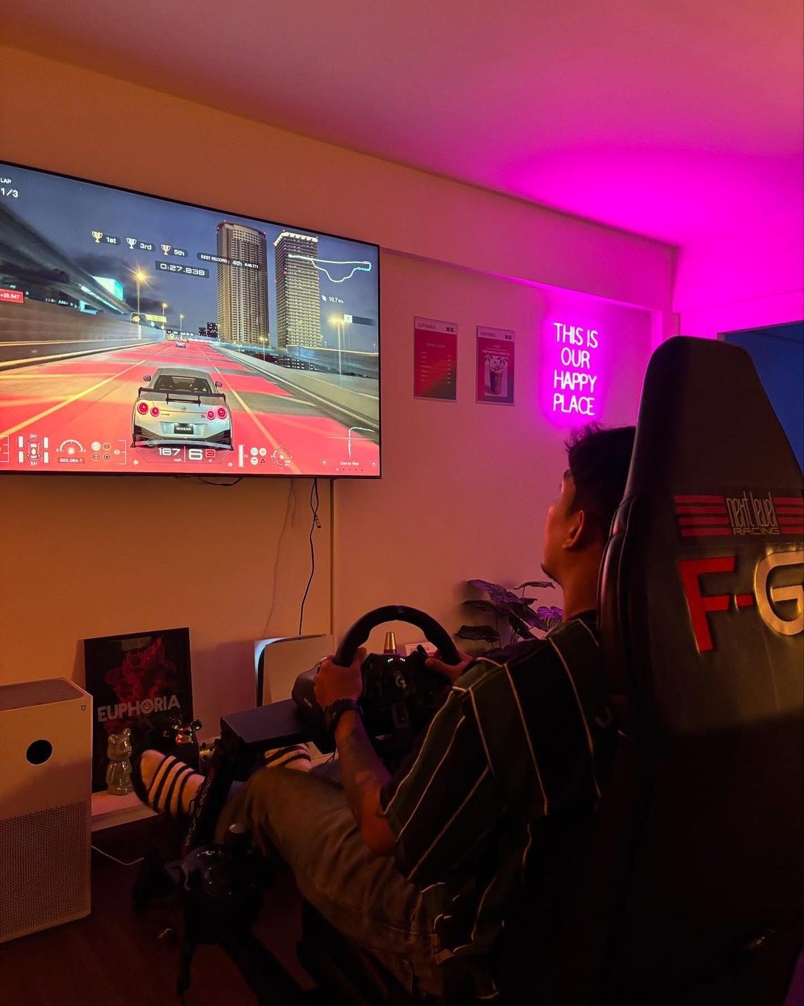 Euphoria cannabis lounge seating area with racing simulator and neon sign